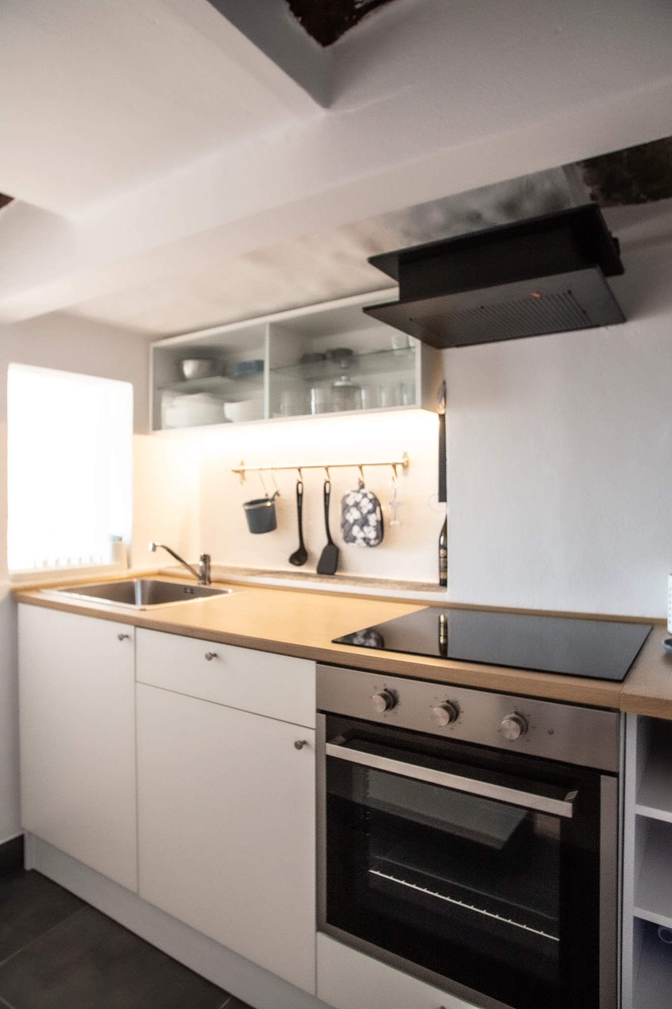 Cucina con forno, piano cottura, lavello e pensili chiari