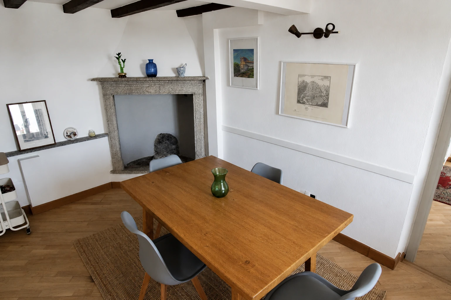 Sala da pranzo con tavolo in legno e camino in pietra