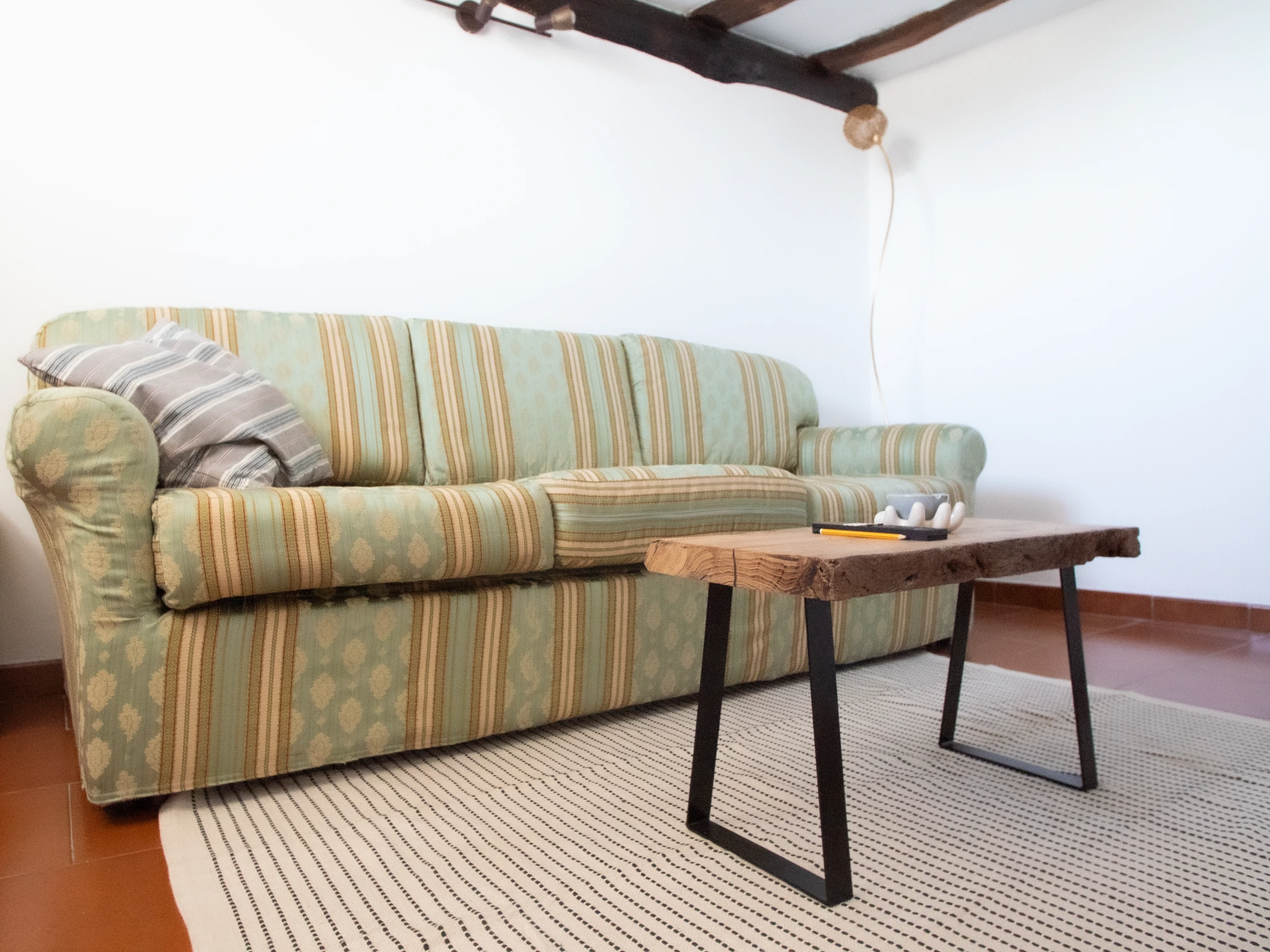 Divano del soggiorno con tavolino in legno e tappeto