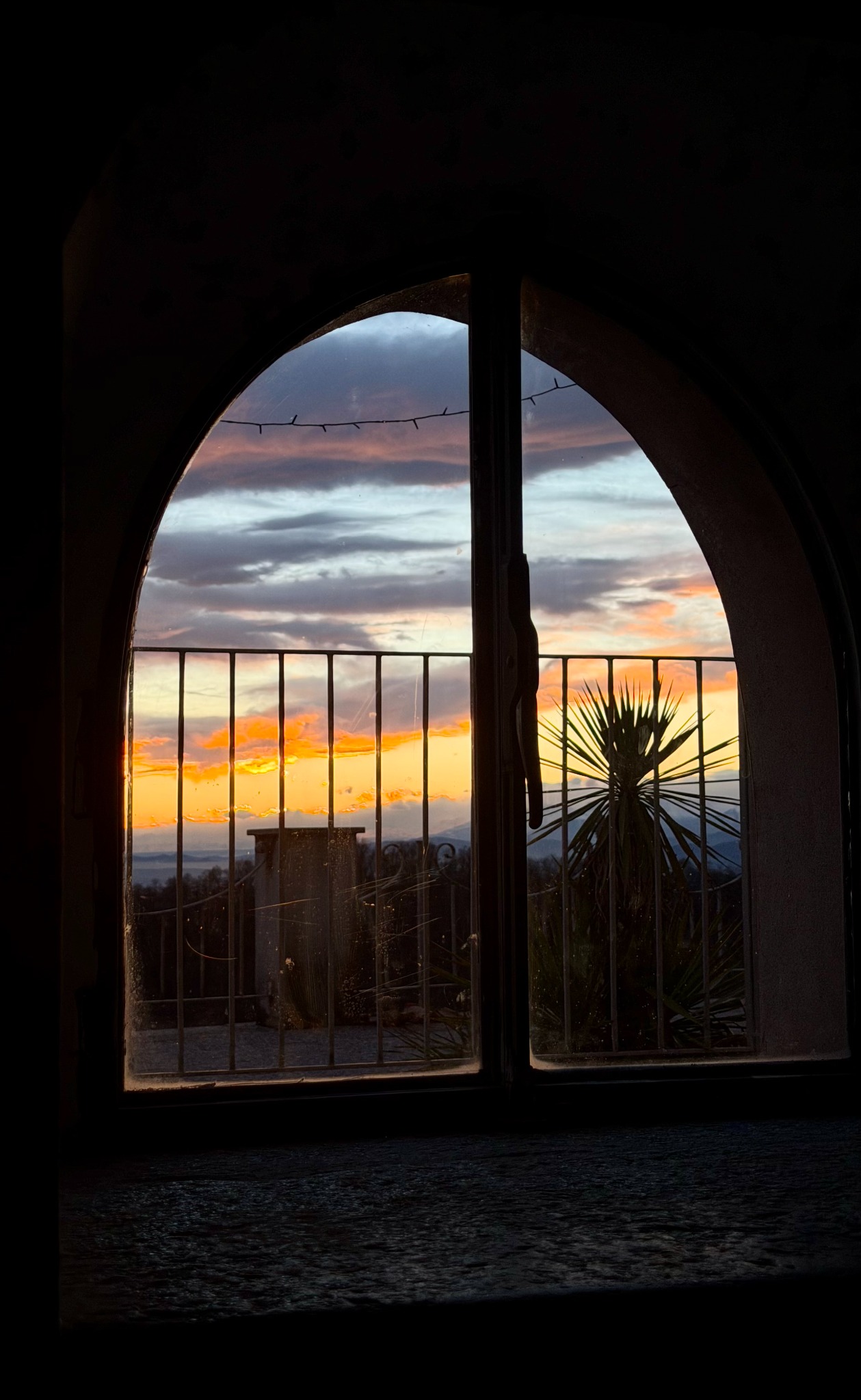 Vista al tramonto attraverso la finestra ad arco del soggiorno